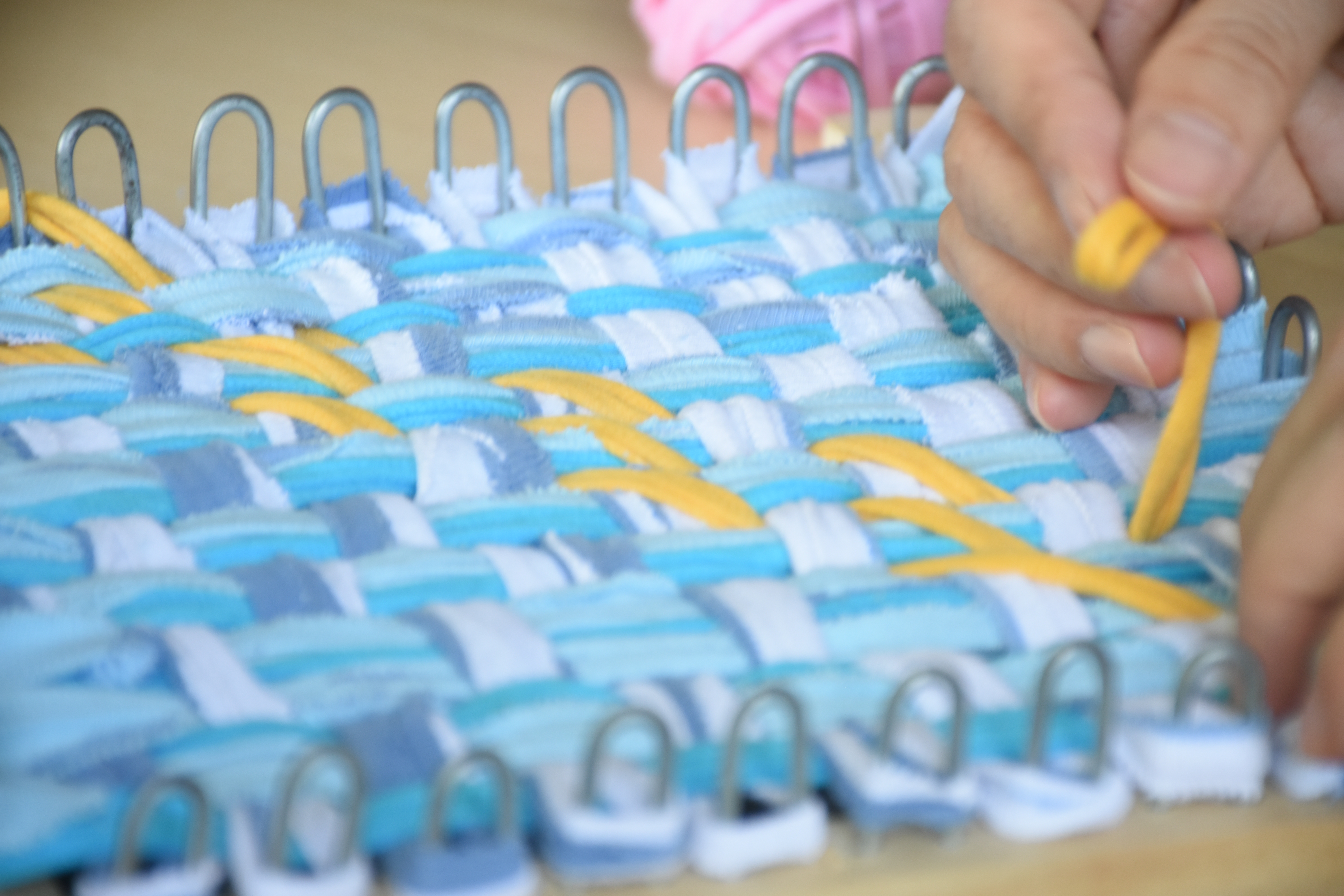Zhuang Xi Hui chose to do crisscross weaving (blue and light blue threads) and diagonal weaving (yellow thread) for the Tikar. (Photo by Wong Siew Kuen)  